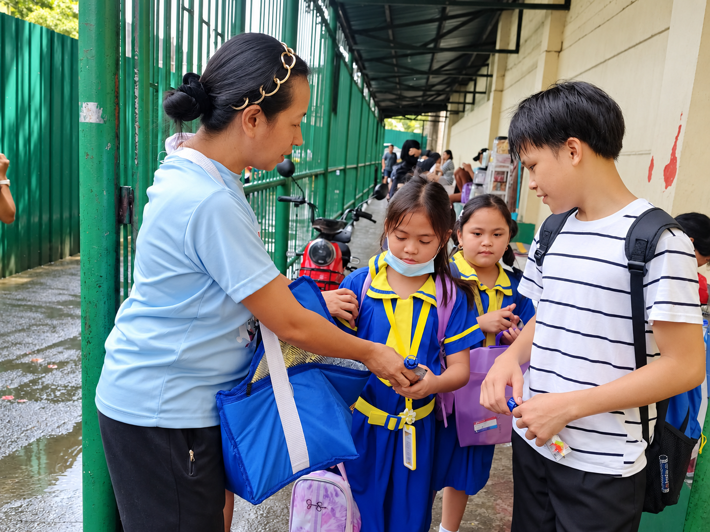 Students receiving Cimory samples with their families at a school gate